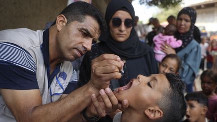 Un agent de santé administre une dose de vaccin contre la polio à un enfant à Gaza, au lendemain de la fin de la trêve humanitaire, le 1er septembre 2024. (EYAD BABA / AFP)