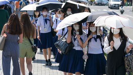 Des jeunes filles se protègent de la chaleur à Kyoto, au Japon, le 17 mai 2023. (MICHIHIRO KAWAMURA / YOMIURI)