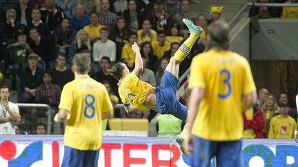 Un soir de novembre 2012, Zlatan se transforme en "Ibracadabra". Durant le match avec la sélection suédoise, il inscrit un but somptueux contre l'Angleterre, un retourné acrobatique à 30 mètres du but pour lober le gardien adverse. Un geste fou, instinctif, d'une précision exceptionnelle et qui demande une dextérité dont l'attaquant a notamment hérité de sa pratique des arts martiaux. Un but "so Zlatan", passé à la postérité, parmi les nombreux bijoux dont il a gratifié la planète football. Ibrahimovic ne parviendra pas néanmoins à faire de la Suède un grand d'Europe, malgré ses 62 buts en 122 sélections. (ALLARD LASSE / AFP)