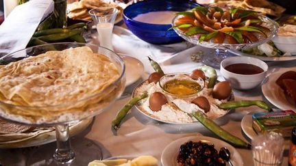 Table de fête sur laquelle trônent terri, farine avec 5 œufs et 5 cosses de fèves fraîches, miel, fruits confits, leben (petit-lait fermenté), levain... (DR capture d&#039;écran)