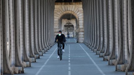 Un cycliste portant un masque FFP2 sur le pont de Bir-Hakeim, 23 mars 2020 à Paris en pleine période de confinement. (NATHANAEL CHARBONNIER / ESP - REDA INTERNATIONALE)