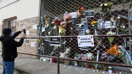 Une personne rend hommage à l'adolescent de 15 ans tué par balles à Bondy (Seine-Saint-Denis), devant l'Espace Nelson-Mandela, où les tirs ont eu lieu, le 28 février 2021.&nbsp; (BERTRAND GUAY / AFP)