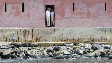 Le pr&eacute;sident am&eacute;ricain Barack Obama (G) et son &eacute;pouse Michelle regardent par la "porte du voyage sans retour" lors d'une visite &agrave; la Maison des esclaves sur l'&icirc;le de Gor&eacute;e (S&eacute;n&eacute;gal), le 27 juin 2013. (SAUL LOEB / AFP)