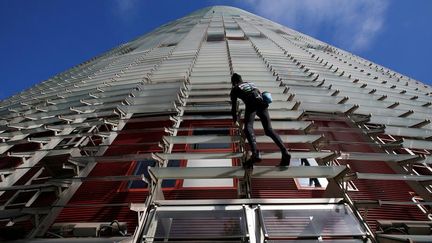 Le "Spiderman"&nbsp;français, Alain Robert, escalade la Torre Agbar à Barcelone, en Espagne, le 25 novembre 2016. (ALBERT GEA / REUTERS)