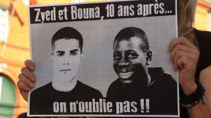 Une manifestante tient&nbsp;une pancarte rendant hommage à Zyed et Bouna, les deux adolescents électrocutés dans un transformateur à Clichy-sous-Bois (Seine-Saint-Denis), le 27 octobre 2005. (PABLO TUPIN / CITIZENSIDE.COM / AFP)