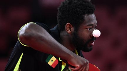 Où est la balle ? Le pongiste sénégalais Ibrahima Diaw au service face au Singapourien&nbsp;Clarence Chew, le 24 juillet 2021, au premier tour du tournoi olympique, à Tokyo (Japon). (ANNE-CHRISTINE POUJOULAT / AFP)