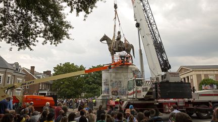 Des habitants observent le déboulonnage de la statue de&nbsp;Thomas Stonewall Jackson,&nbsp;l’un des principaux généraux de l’armée sudiste et confédérée, à Richmond, aux États-Unis. (RYAN M. KELLY / AFP)