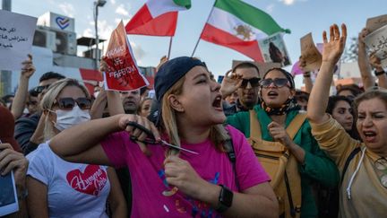 Une femme se coupe&nbsp;les cheveux en soutien aux femmes iraniennes,&nbsp;à Istanbul en Turquie le 2 octobre 20022.
 (BULENT KILIC / AFP)