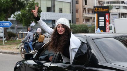 Une femme réagit à l'accord de cessez-le-feu sur une route menant au sud du Liban, à Sidon, le 27 novembre 2024. (ANWAR AMRO / AFP)