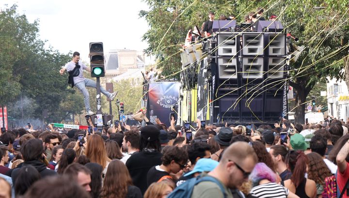 Il danse accroché à un feu au milieu de la foule, lors de la 25e Techno Parade, samedi 23 septembre 2023 à Paris (France). (JEAN-BAPTISTE QUENTIN / MAXPPP)