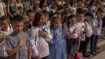 Des élèves chantent l'hymne national ukrainien lors de la rentrée scolaire à Kiev, en Ukraine, le 1er septembre 2023. (ROMAN PILIPEY / AFP)