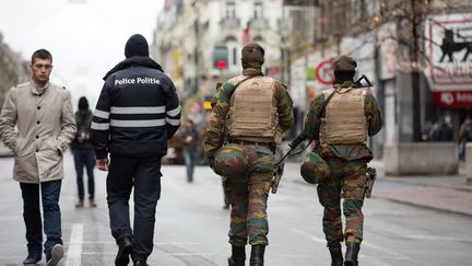 Un policier et des militaires patrouillent dans les rues de Bruxelles (Belgique), le 22 novembre 2015.&nbsp; (OCTAVIAN CARARE / MAXPPP)