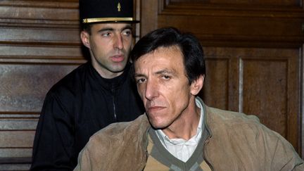 L'écrivain français Serge Livrozet le 13 novembre 1989, lors de sa comparution devant la cour d'assises de Paris pour contrefaçon de billets, une affaire dans laquelle il fut acquitté. (JEAN-LOUP GAUTREAU / AFP)