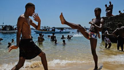 Deux hommes s'entraînent à la capoeira sur la plage de Boa Viagem, à Recife au Brésil. (YASUYOSHI CHIBA / AFP)