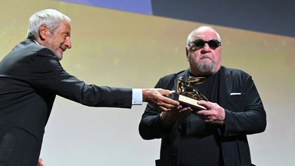 Le cinéaste Paul Schrader reçoit un Lion d'Or d'honneur des mains de Roberto Cicutto, président de la Mostra, le 3 septembre 2022 à Venise (TIZIANA FABI / AFP)