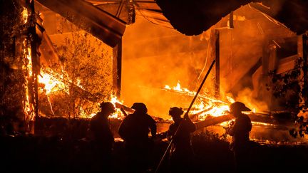 Des pompiers tentent de maîtriser le feu qui ravage une habitation, à l'est de Healdsburg en Californie, le 29 octobre 2019. (PHILIP PACHECO / AFP)