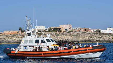 Des migrants venus de Tunisie et de Libye arrivent au large de Lampedusa (Italie) sur un bateau des gardes-côtes italiens, le 1er août 2020.&nbsp; (ALBERTO PIZZOLI / AFP)