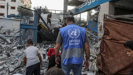 Des Palestiniens et des travailleurs de l'ONU examinent les tentes et les abris de fortune détruits après une attaque israélienne, à Gaza, le 15 juillet 2024. (ABED RAHIM KHATIB / ANADOLU)