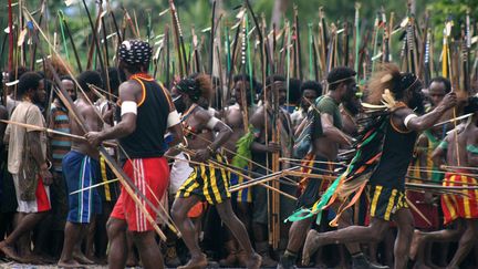 Des guerriers papous arm&eacute;s d'arcs et de fl&egrave;ches partent en guerre contre un village voisin &agrave; Mimika (Indon&eacute;sie), le 20 juin 2012. (TJAHJONO ERANIUS / AFP)