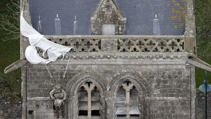 Un mannequin &agrave; l'effigie du militaire am&eacute;ricain John Steele est accroch&eacute; par son parachute sur le toit de l'&eacute;glise &agrave; Sainte-M&egrave;re-Eglise (Manche), le 29 mars 2014. (CHRISTIAN HARTMANN / REUTERS)