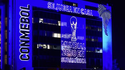 Vue du siège de la Confédération sud-américaine de football (Conmebol), décoré de lumières annonçant l'organisation de la Coupe du monde 2030 dans six pays, l'Espagne, le Portugal, le Maroc ainsi qu'en Uruguay, Paraguay et Argentine à Luque, au Paraguay, le 5 octobre 2023, (NORBERTO DUARTE / AFP)