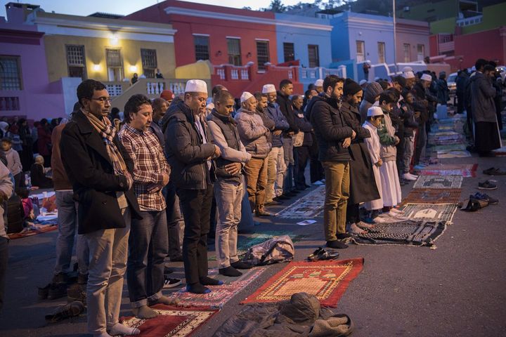 Des hommes prient après la célébration de l'iftar, à Wale Street, dans le quartier de Bo-Kaap, le 1er juin 2018 (RODGER BOSCH / AFP)