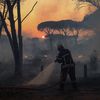 Un pompier lutte contre les flammes d'un feu de forêt, le 17 août 2021 à Gonfaron (Var). (NICOLAS TUCAT / AFP)