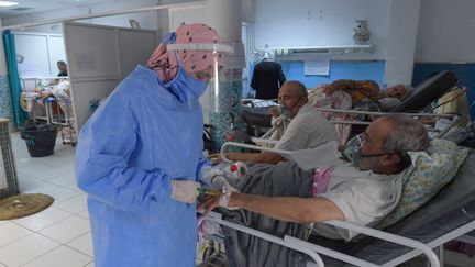 Un infirmier prodigue les premiers soins aux patients atteints de Covid-19 aux urgences de l'hôpital Charles Nicole à Tunis (Tunisie), le 16 juillet 2021. Photo d'illustration. (FETHI BELAID / AFP)