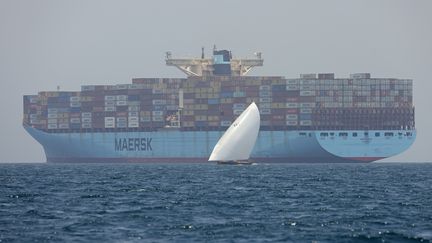 Des marins passent devant le porte-conteneurs "Ebba Maersk", près de l'île de Sir Abu Nuair (Emirats arabes unis) en direction de l'émirat du Golfe de Dubaï, le 4 juin 2022. (KARIM SAHIB / AFP)