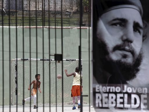 Des enfants jouent au football à La Havane derrière une affiche représentant Fidel Castro le 29 mai 2015. (REUTERS - Enrique de la Osa)