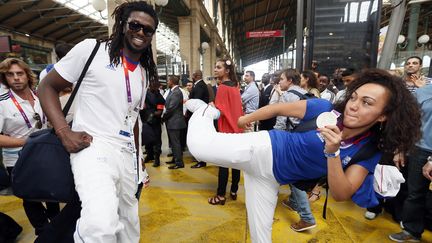 Ambiance d&eacute;contract&eacute;e entre la championne de taekwondo Anne-Caroline Graffe et le handballeur Daouda Karabou&eacute;, &agrave; l'arriv&eacute;e en gare du Nord, &agrave; Paris. (KENZO TRIBOUILLARD / AFP)