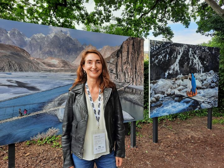 La photographe française Sarah Caron devant sa photo "Le pays des purs", exposée à La Gacilly (Morbihan) le 8 juin 2022. (ANNE CHEPEAU / FRANCEINFO / RADIO FRANCE)