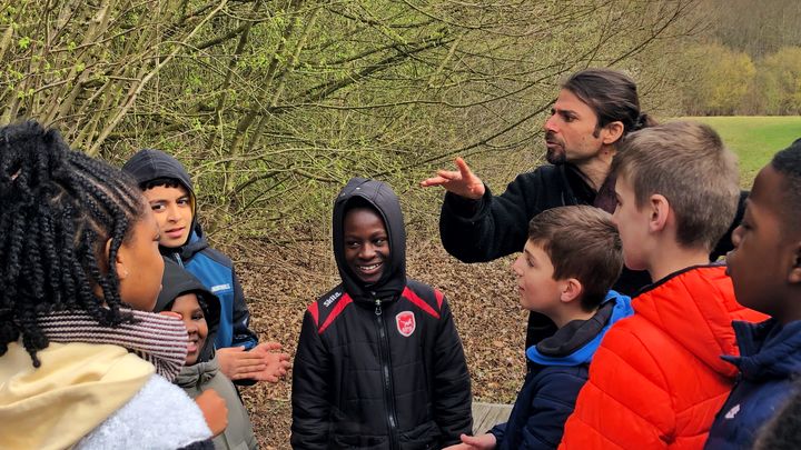 Au cours d'une balade contée organisée lundi 20 mars 2023 au parc du Sausset, à Aulnay-sous-Bois (Seine-Saint-Denis), l'intervenant botaniste Laurent Azuelos fait participer les élèves aux histoires. (RACHEL RODRIGUES / FRANCEINFO)