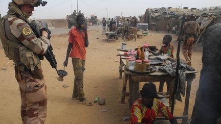 Militaire français de l'opération Barkhane en train de discuter avec un commerçant malien à Gossi (centre du Mali) le 25 mars 2019 (DAPHNE BENOIT / AFP)