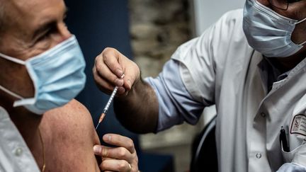 Un médecin administre un vaccin dans le centre de vaccination des Hospices de Lyon, le 5 janvier 2021. (JEFF PACHOUD / AFP)