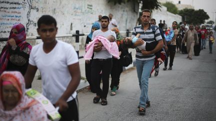 Des familles palestiniennes fuient leur domicile, en raison des bombardements isra&eacute;liens, le 23 juillet 2014, dans le sud de la bande de Gaza. ( IBRAHEEM ABU MUSTAFA / REUTERS)