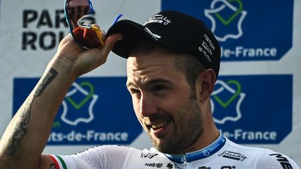 Sonny Colbrelli savoure sa victoire sur le podium de Paris-Roubaix, le 3 octobre 2021. (ANNE-CHRISTINE POUJOULAT / AFP)