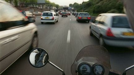 Un motard se faufile entre les voitures sur le périphérique à Paris (AFP PHOTO PIERRE-FRANCK COLOMBIER)