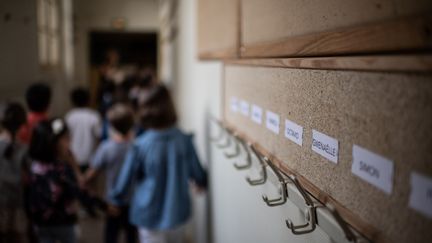 Des&nbsp;enfants entrent dans leur classe à l'école élémentaire Chaptal à Paris, le 2 septembre 2019.&nbsp;Photo d'illustration. (MARTIN BUREAU / AFP)