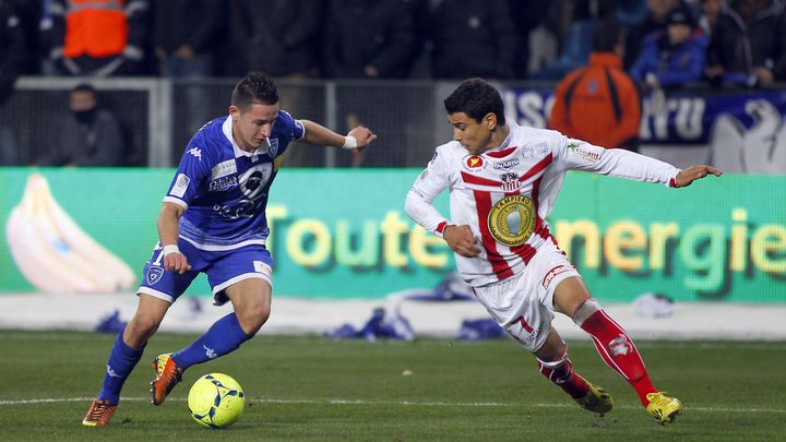 Le Bastiais Florian Thauvin (en bleu) face &agrave; l'Ajaccien Yohan Poulard (en blanc et rouge) lors du derby corse, le 2 mars 2013.&nbsp; (PHILIPPE MARINI / AFP)