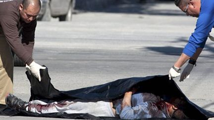 Des policiers recouvrent un homme tué par des trafiquants de drogue, à Ciudad Juarez, le 12 janvier 2010 (AFP PHOTO/Jesus Alcazar)