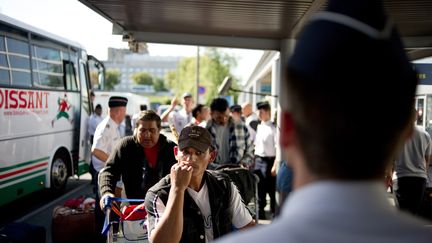 Des Roms b&eacute;n&eacute;ficiant de "l'aide au retour humanitaire" arrivent &agrave; l'a&eacute;roport de Roissy-Charles de Gaulle pour prendre un vol vers Bucarest (Roumanie), le 20 ao&ucirc;t 2010. (FRED DUFOUR / AFP)