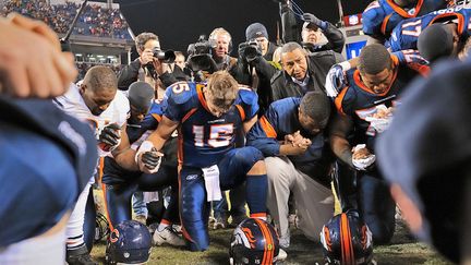 Tim Tebow en train de prier , entour&eacute; d'une foule de photographes, &agrave; Denver, le 12 novembre 2011.&nbsp; (AL TIELEMANS / GETTY IMAGES)