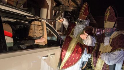 Des artistes de la troupe pragoise&nbsp;Cirk La Putyka déguisés en Saint-Nicolas distribuent des cadeaux aux enfants dans des voitures, une cérémonie traditionnelle maintenue malgré la pandémie, à Prague, le 5 décembre 2020. (MICHAL CIZEK / AFP)