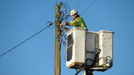 Un technicien répare une ligne électrique à Tregunc (Finistère), le 13 janvier 2017.&nbsp; (FRED TANNEAU / AFP)