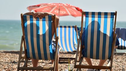 Des vacanciers en bord de mer, à Brighton (Angleterre), le 24 juillet 2019 (illustration). (GLYN KIRK / AFP)