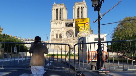 Fidèle priant devant la cathédrale Notre-Dame de Paris, le 15 avril, pendant que le bourdon résonne, un an après l'incendie de l'édifice.&nbsp; (BENJAMIN  ILLY / RADIOFRANCE)