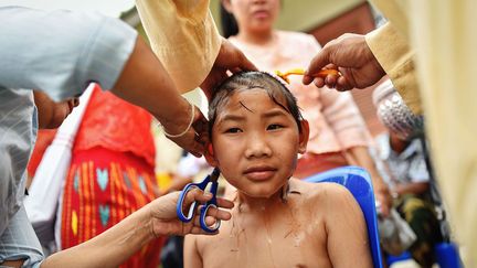 Pour commencer, les garçons reçoivent d’abord des cadeaux de leur famille. Puis à l’aube, ils prennent un bain et leur crane est rasé en signe de purification.  (Li Mangmang/Xinhua/Sipa)