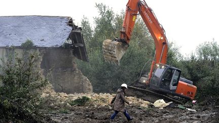 Un bulldozer d&eacute;truit une maison sur le site du futur a&eacute;roport de Notre-Dame-des-Landes, pr&egrave;s de Nantes (Loire-Atlantique), le 17 octobre 2012.&nbsp; (JEAN-SEBASTIEN EVRARD / AFP)