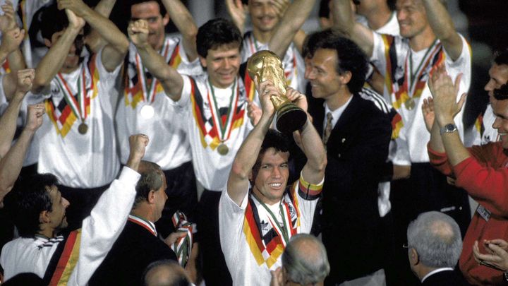 Lothar Matthaüs soulève la Coupe du monde devant ses coéquipiers de l'équipe de la RFA, sous les yeux du sélectionneur Franz Beckenbauer (à droite), le 8 juillet 1990. (CARLO FUMAGALLI / AP/ SIPA)